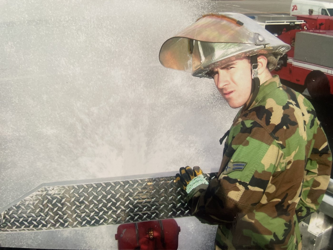 Brendan as an Air Force firefighter, in uniform at the truck